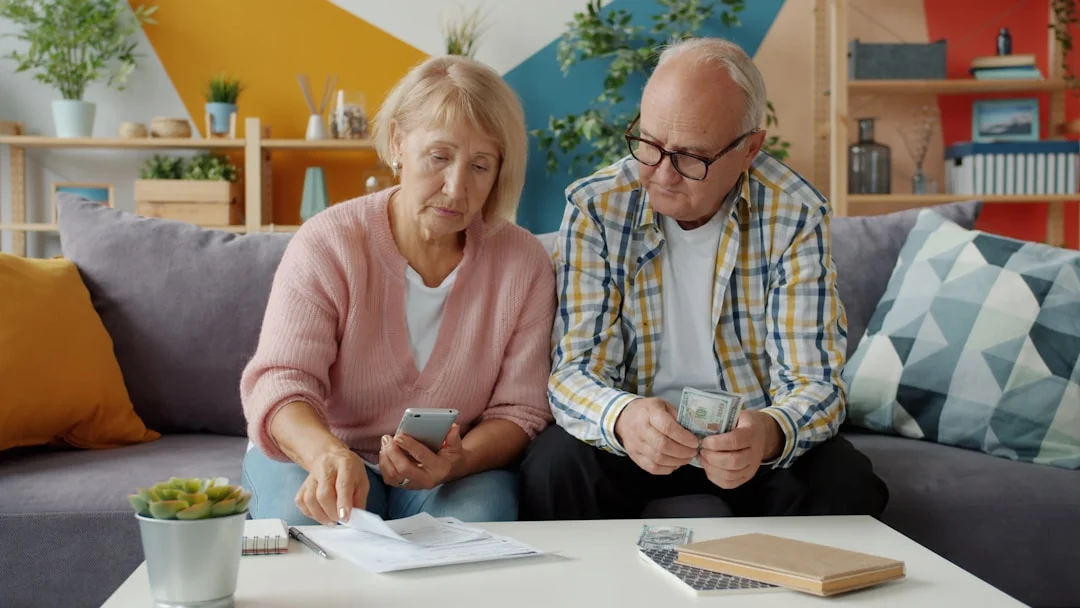 Elderly couple reviewing financial documents and bills for year-end planning